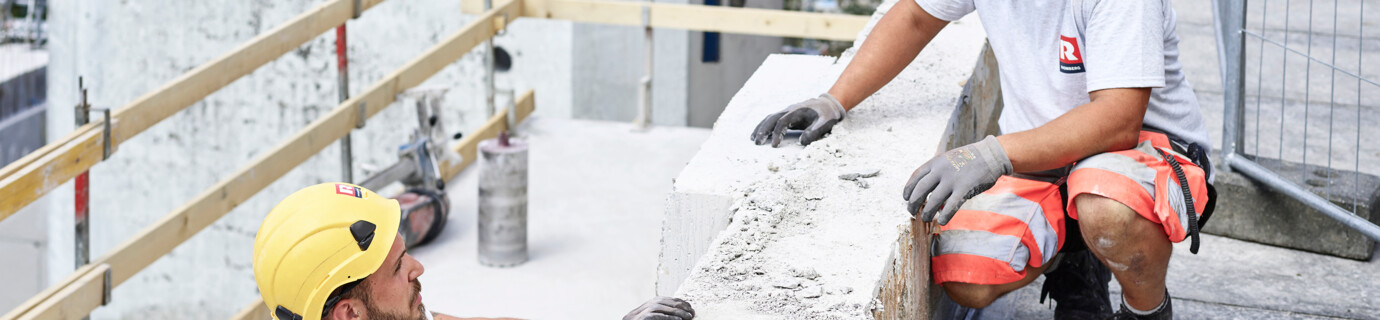 Angebot Mitarbeiter Rhomberg Bau Bauarbeiter, die sich auf Baustelle unterhalten