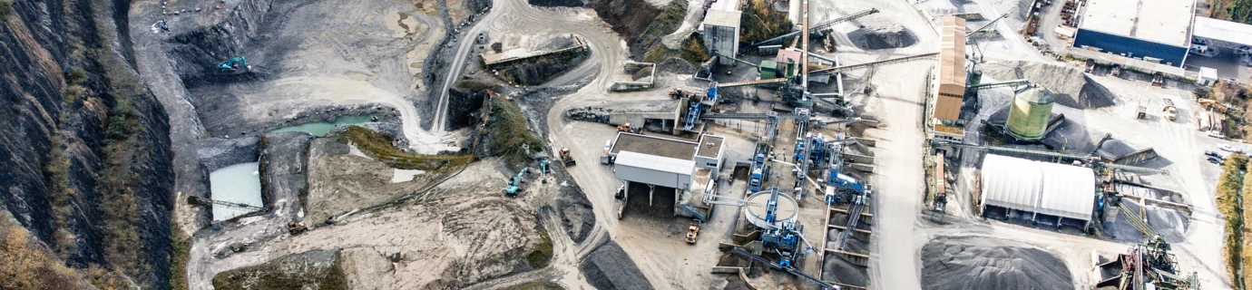 Luftbild eines Steinbruchs mit Förderbändern und Schutthalden (Ressourcencenter, Rheintal)