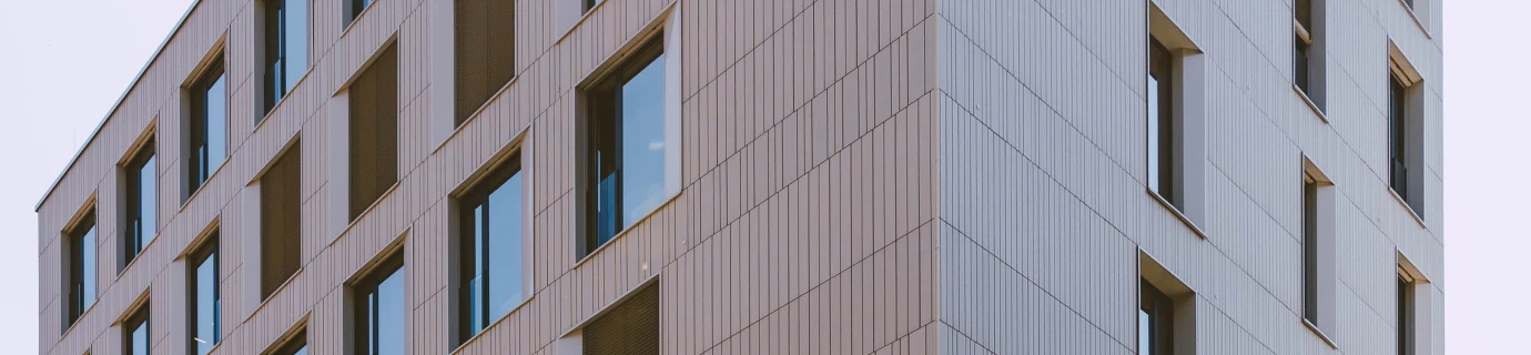 Modernes Gebäude mit holzverkleideten Fassaden und vielen Fenstern in einem städtischen Umfeld. Der Schriftzug "STURMHAUS" ist an der Fassade erkennbar (Baerahus, Feldkirch).