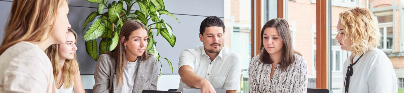Mitarbeiter am Arbeitsplatz Büro Office Tablet Laptop Besprechung großer Tisch