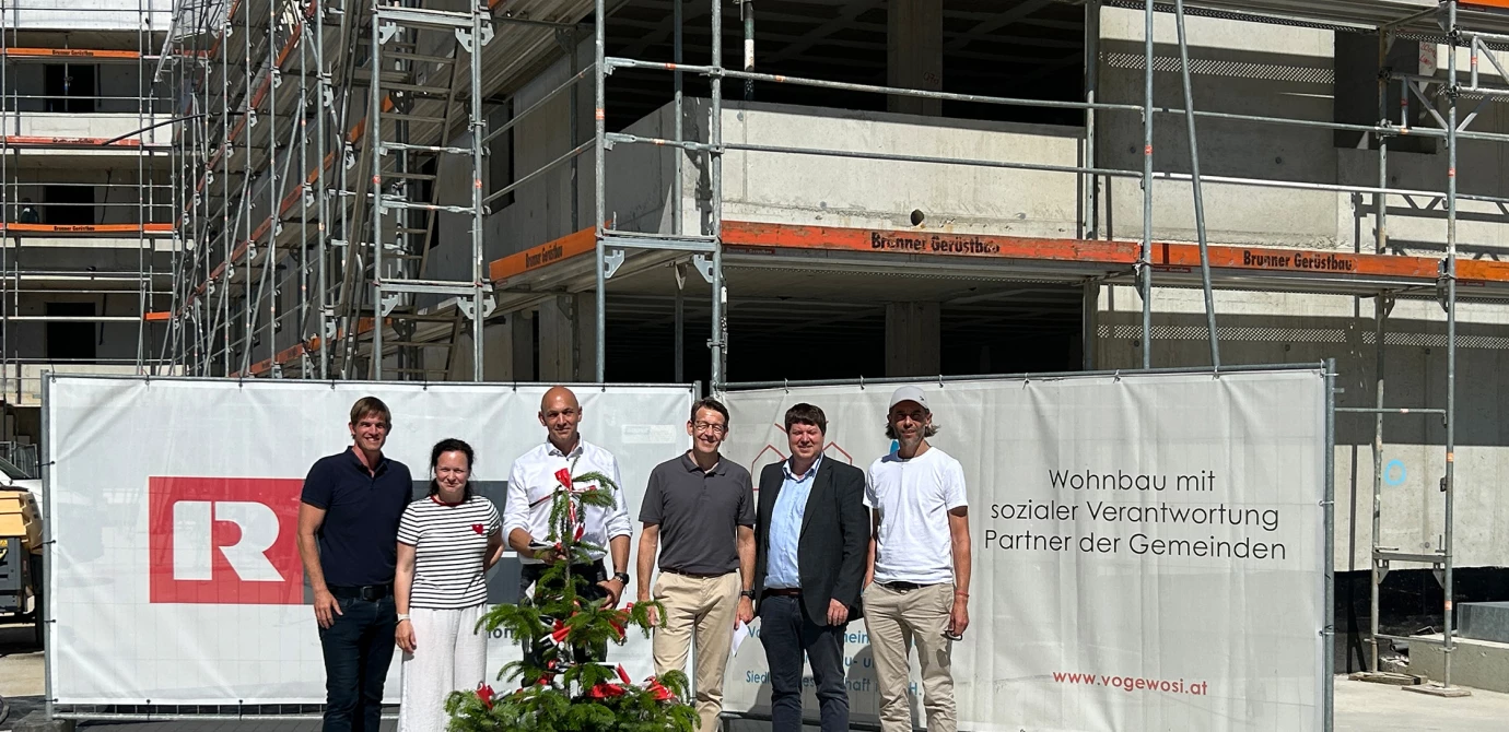 Bedankten sich gemeinsam bei den Handwerker:innen des Wohnbauprojekts in der Bregenzer Holzackergasse: Verantwortliche von Bauherr, Generalunternehmen und Architekt um den künftigen VOGEWOSI-Geschäftsführer Manfred Bauer (3. v. r.) und Rhomberg Bau-Geschäftsführer Daniel Leitinger (2. v. r.). Bildquelle: Rhomberg Bau