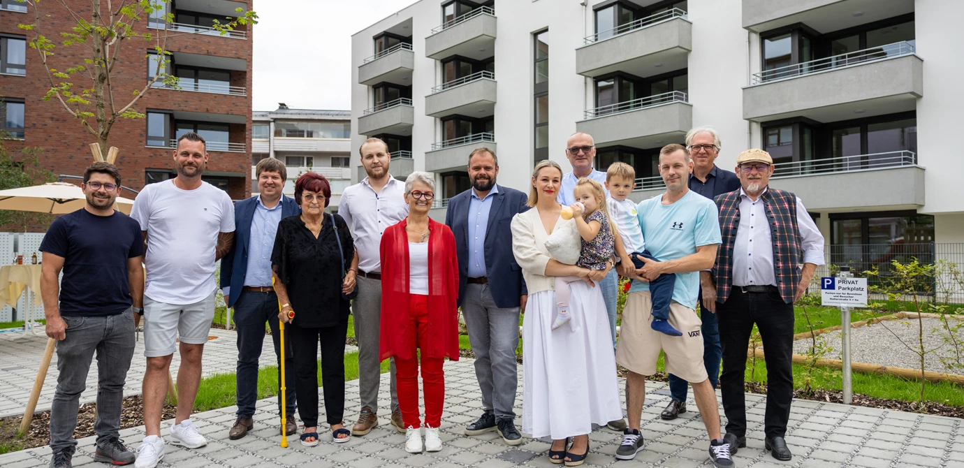 Freuten sich über den erfolgreichen Abschluss des gemeinsamen Bauprojekts: Bauherrin Pia Lengauer (Mitte, in Rot) mit Rhomberg Bau-Geschäftsführer Daniel Leitinger (3. v. l.), Architekt Reinhard Drexel (2. v. r.), Bürgermeister Markus Fäßler (7. v. l.) sowie Familienmitgliedern und Freunden. Bildnachweis: Rhomberg Bau