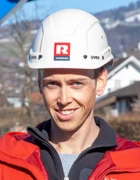 Florian Egle steht vor Bagger auf Baustelle für Web