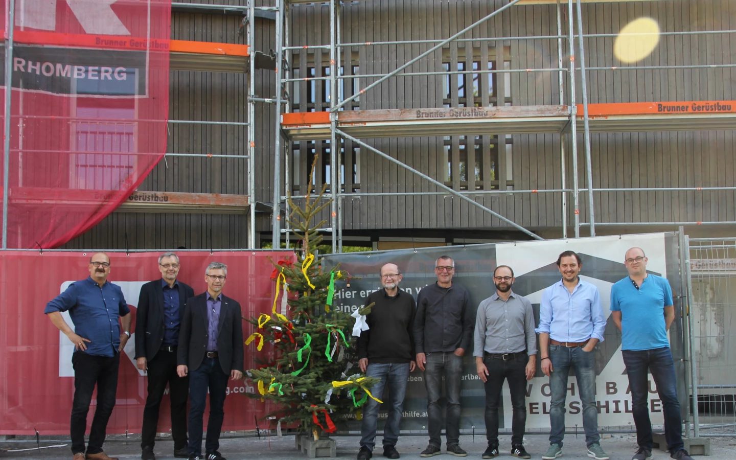 Gruppenbild mit Firstbaum: Die Verantwortlichen von Wohnbauselbsthilfe, Rhomberg Bau, Gemeinde und Architekt bei der Gleichenfeier in Dornbirn.