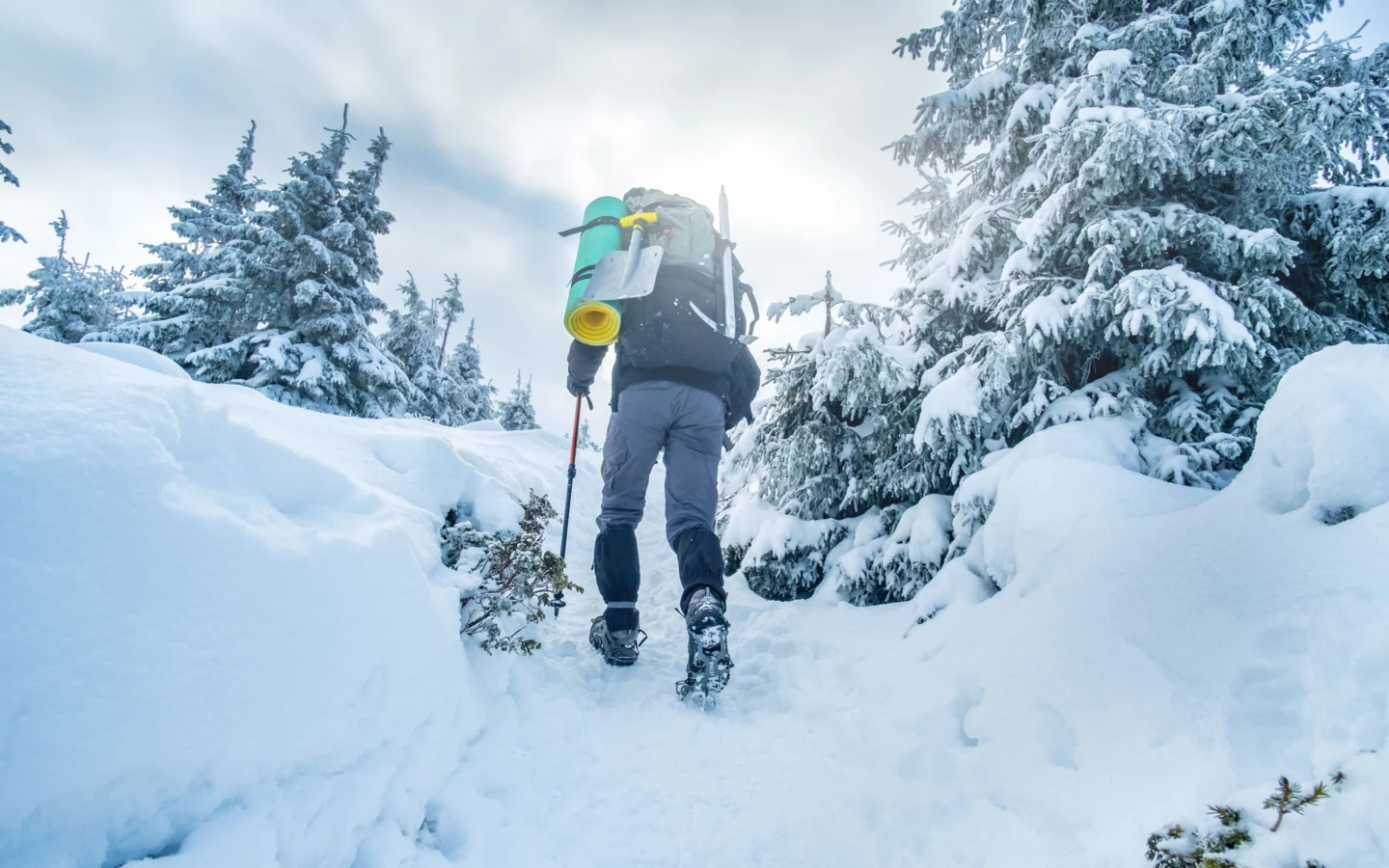 tourist-climbing-snowy-mountain-in-winter