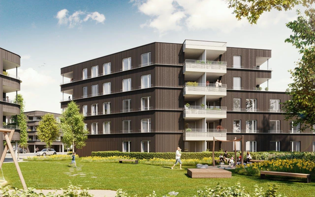 Modernes Wohnhaus mit dunkler Holzfassade, Balkonen und einem belebten Spielplatz im Grünen (Rheindorf)
