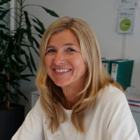 Lisa Ehrat wie sie an einem Schreibtisch mit einem Mann sitzt und in die Kamera lächelt Lisa Ehrat wie sie an einem Schreibtisch mit einem Mann sitzt und in die Kamera lächelt