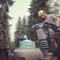 Patrick Schedler Tiefbau mit Presslufthammer und Wald im Hintergrund