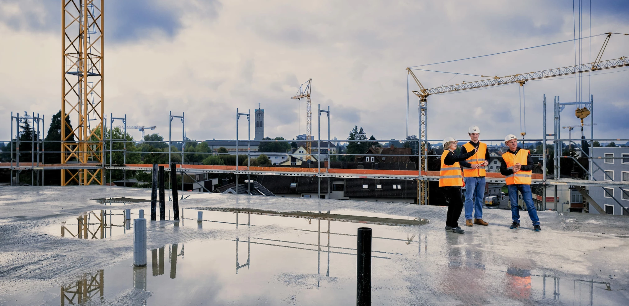 Rhomberg-bau-mitarbeiter-bauleiter-team-am-dach-auf-der-Baustelle