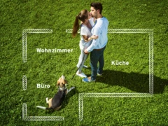 Mann und Frau küssen sich auf Wiese mit Hund und Grundriss von Haus im Hintergrund 4