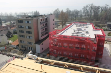 Machen bereits eine gute Figur: Zwei der neu errichteten Baukörper im „Bäumlequartier am See“ von Rhomberg Bau. Im Vordergrund ist das Dach der originalgetreu nachgebauten alten Fabrikhalle zu sehen. Bereits im Herbst wird der zweite und finale Bauabschnitt starten.