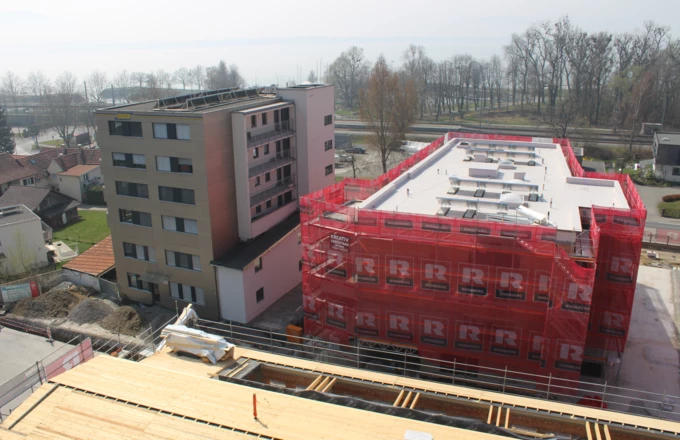 Machen bereits eine gute Figur: Zwei der neu errichteten Baukörper im „Bäumlequartier am See“ von Rhomberg Bau. Im Vordergrund ist das Dach der originalgetreu nachgebauten alten Fabrikhalle zu sehen. Bereits im Herbst wird der zweite und finale Bauabschnitt starten.