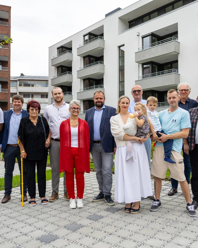 Freuten sich über den erfolgreichen Abschluss des gemeinsamen Bauprojekts: Bauherrin Pia Lengauer (Mitte, in Rot) mit Rhomberg Bau-Geschäftsführer Daniel Leitinger (3. v. l.), Architekt Reinhard Drexel (2. v. r.), Bürgermeister Markus Fäßler (7. v. l.) sowie Familienmitgliedern und Freunden. Bildnachweis: Rhomberg Bau
