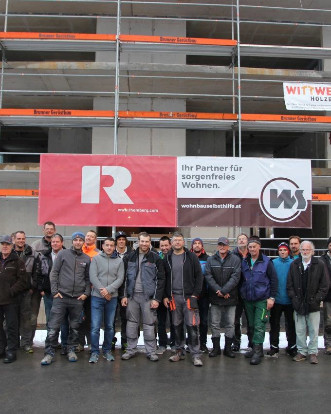 Partenens Vize-Bürgermeisterin Ruth Tschofen und Wohnbauselbsthilfe-Geschäftsführer Thomas Schöpf feiern gemeinsam mit Vertretern von Rhomberg Bau sowie Handwerkern die Firstfeier.