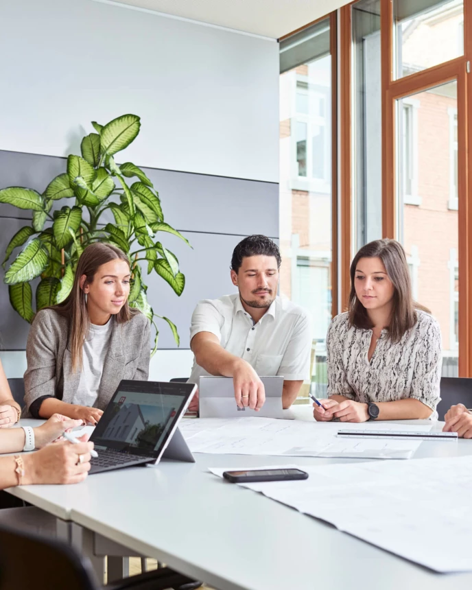 Mitarbeiter am Arbeitsplatz Büro Office Tablet Laptop Besprechung großer Tisch