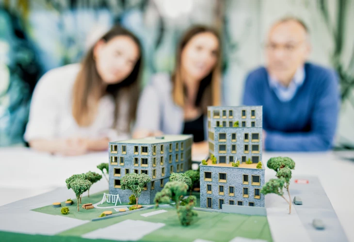 Projektentwicklung-besichtigung-model-mit-team-im-hintergrund