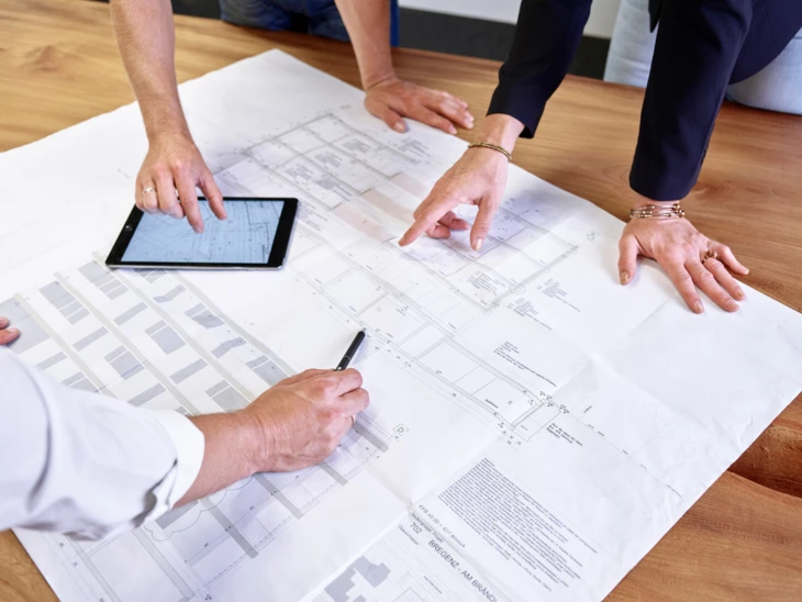 Hände von verschiedenen Menschen auf Plan und diskutieren darüber Hände von verschiedenen Menschen auf Plan und diskutieren darüber