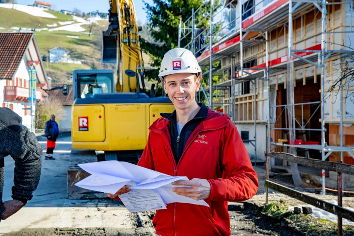 Florian Egle schaut sich Plan an vor Bagger für Web