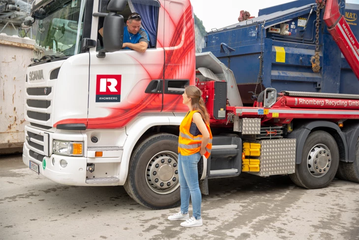 Marilyn Kaufmann steht auf Baustelle vor LKW und spricht mit dem Fahrer