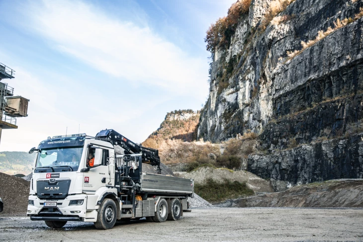 Ein Rhomberg Bau Lkw in einem Steinbruch, im Hintergrund ist eine steile Felswand zu sehen (Ressourcen Center Rheintal).