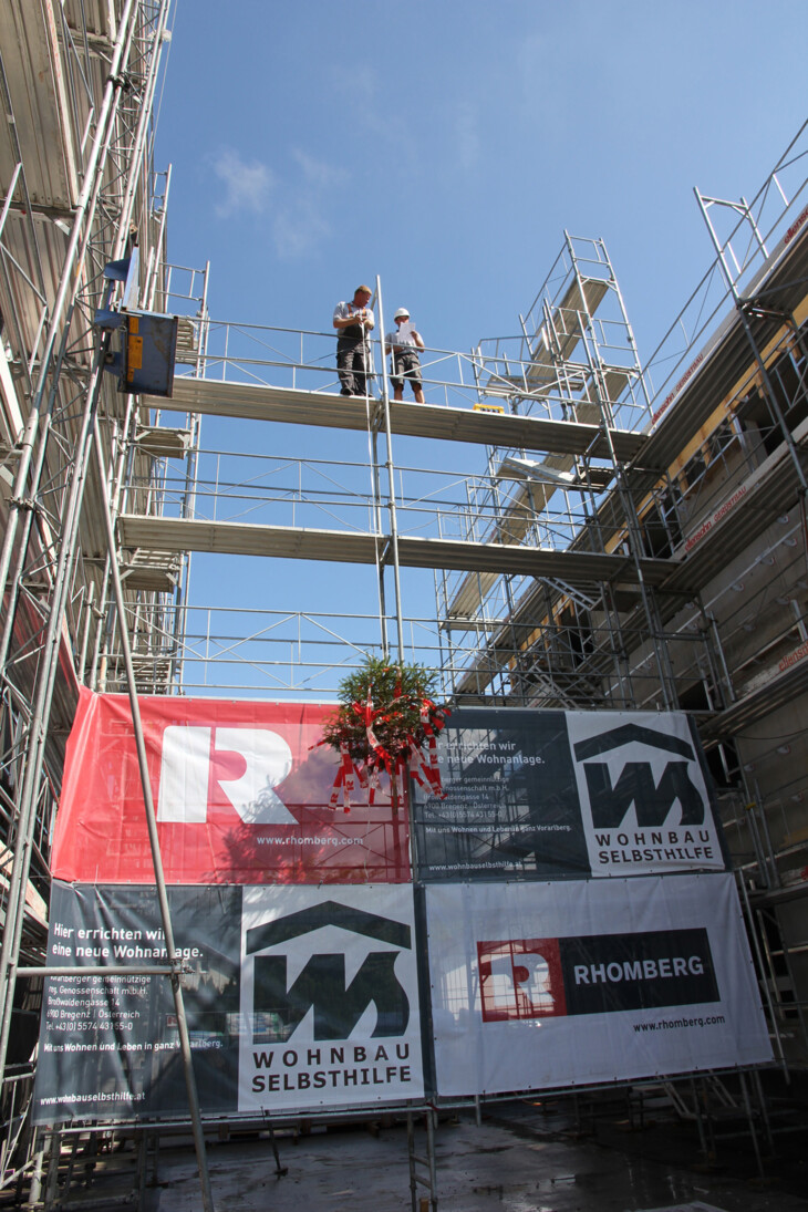 Das Aufziehen des Firstbaums an der Wohnanlage von Wohnbauselbsthilfe und Rhomberg Bau in der Lustenauerstraße, Hohenems. Bildnachweis: Rhomberg Bau