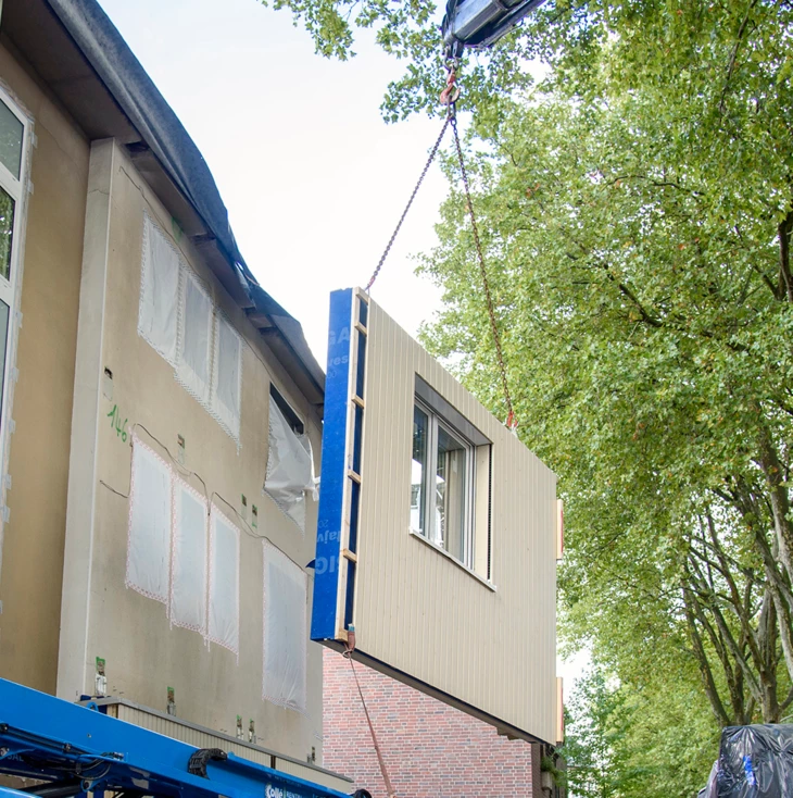 Sanieren in Serie: Am gestrigen Donnerstag wurde die erste Großflächenpaneele für die Fassadenisolierung am Pilotprojekt der Renowate GmbH montiert. Sanieren in Serie: Am gestrigen Donnerstag wurde die erste Großflächenpaneele für die Fassadenisolierung am Pilotprojekt der Renowate GmbH montiert.