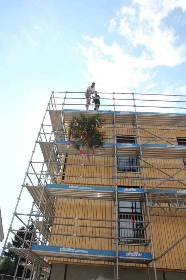 Hoch hinaus: Der Firstbaum auf seinem Weg auf das Dach der Holzbau-Wohnanlage in Meiningen.