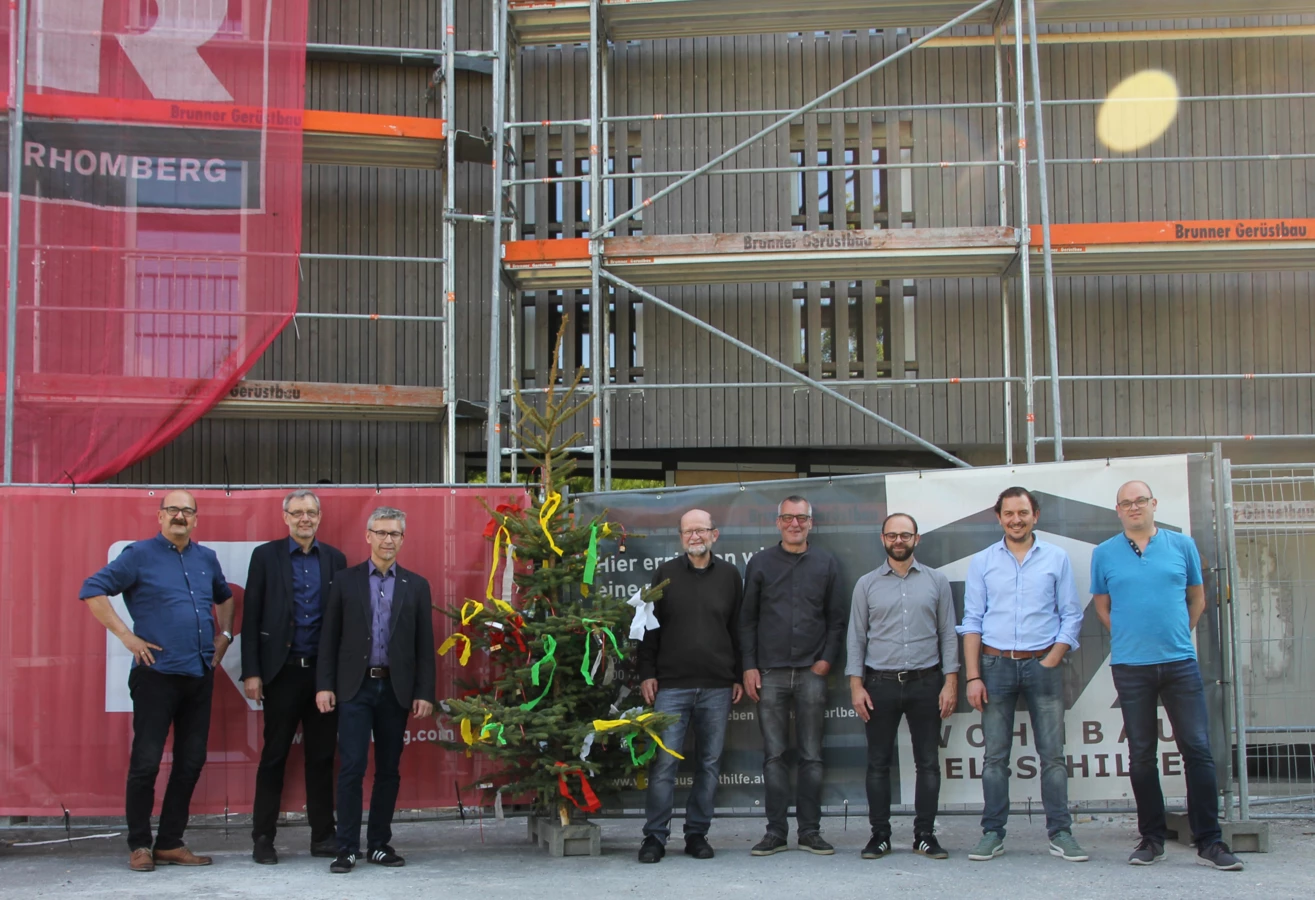 Gruppenbild mit Firstbaum: Die Verantwortlichen von Wohnbauselbsthilfe, Rhomberg Bau, Gemeinde und Architekt bei der Gleichenfeier in Dornbirn.
